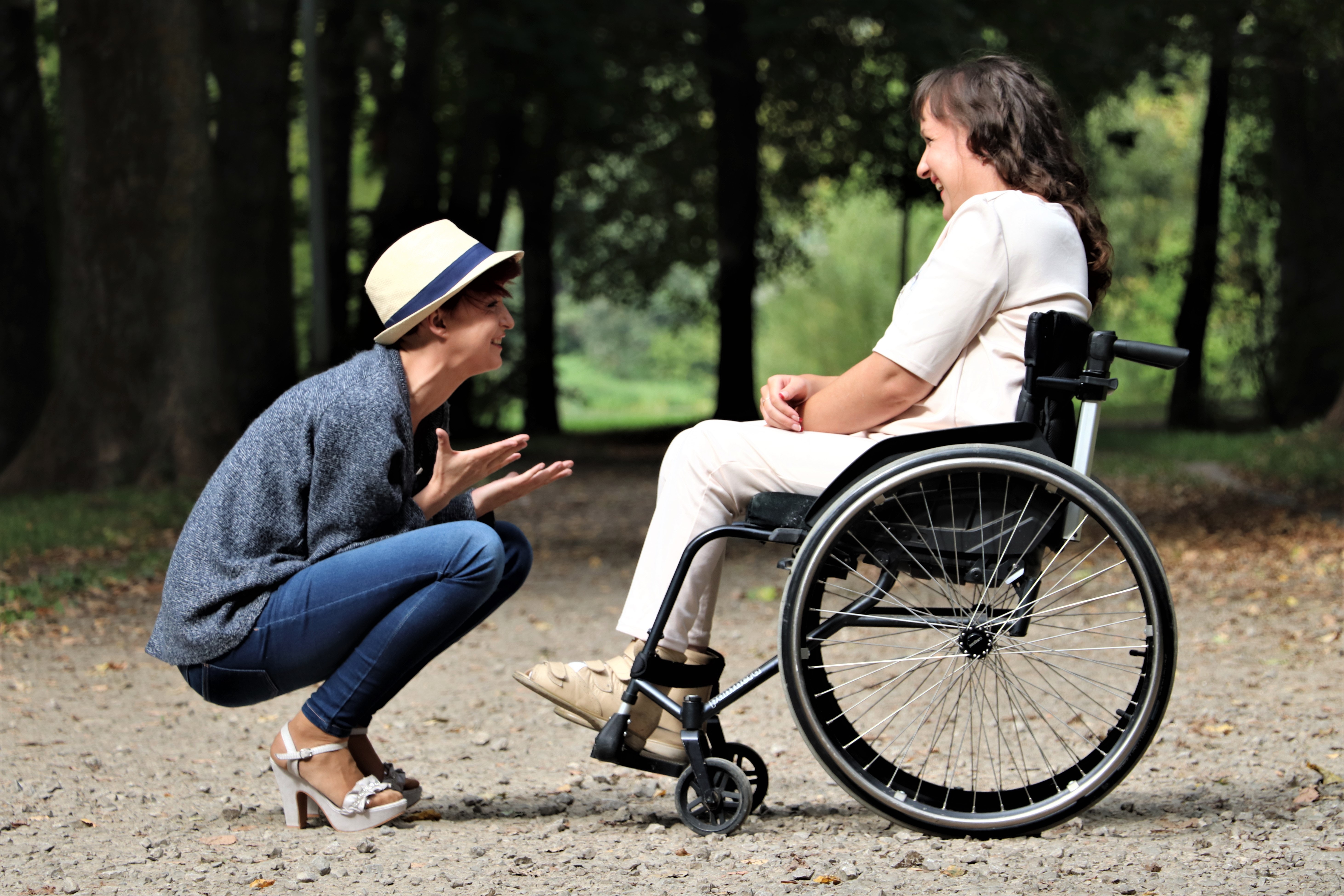 woman talking to woman who uses wheelchair