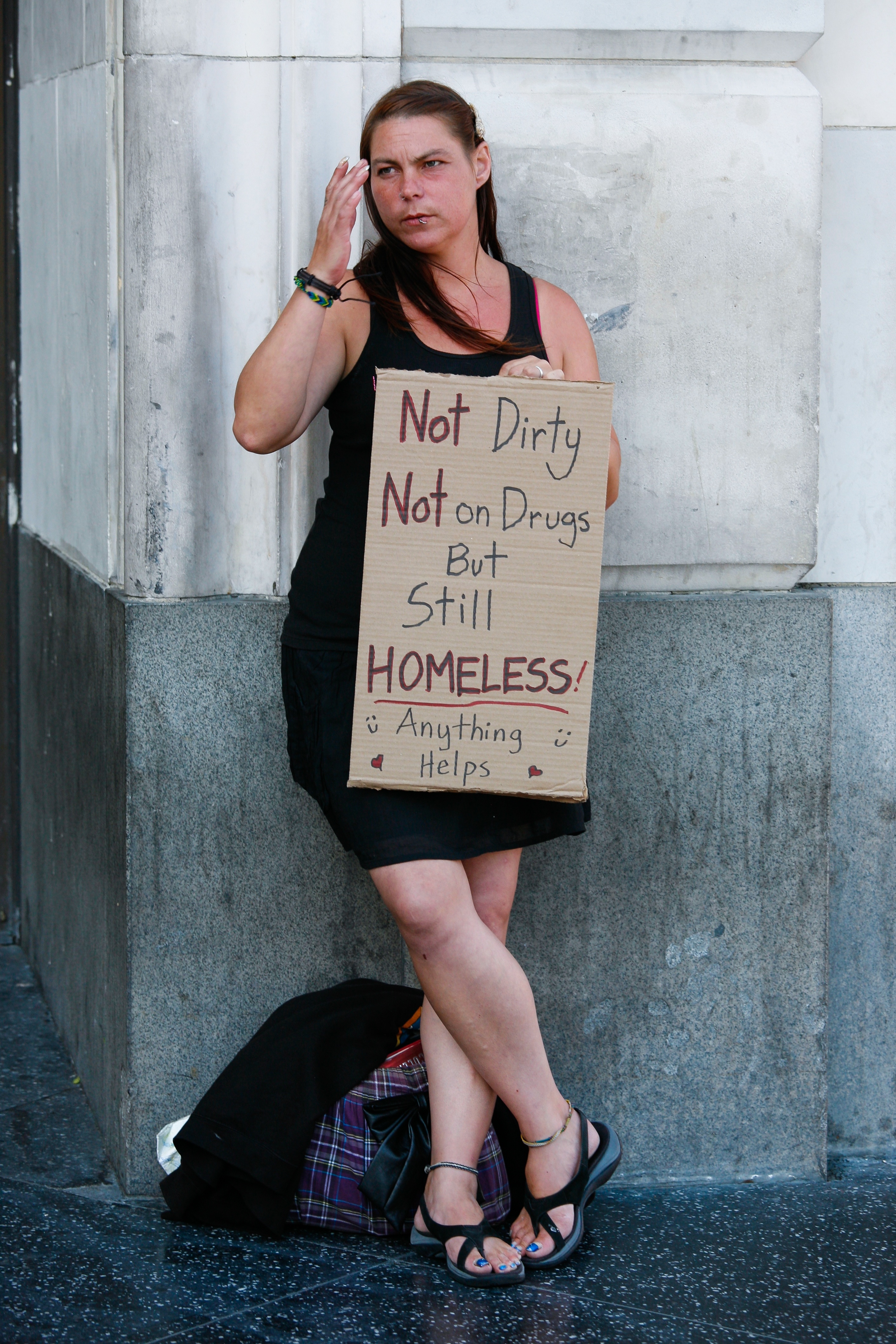 white homeless female holding sign
