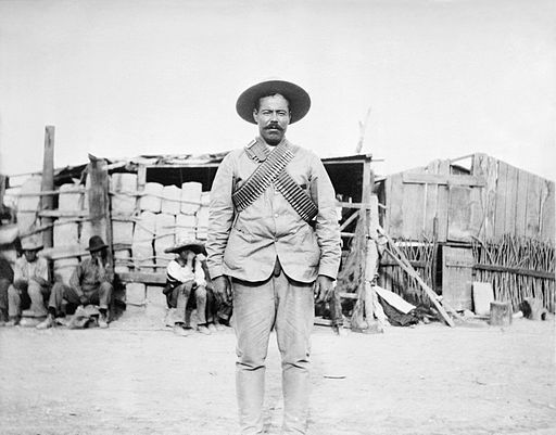 Francisco “Pancho” Villa wearing bandoliers in front of an insurgent camp. By Bain News Service derivative work: Hic et nunc [Public domain], via Wikimedia Commons