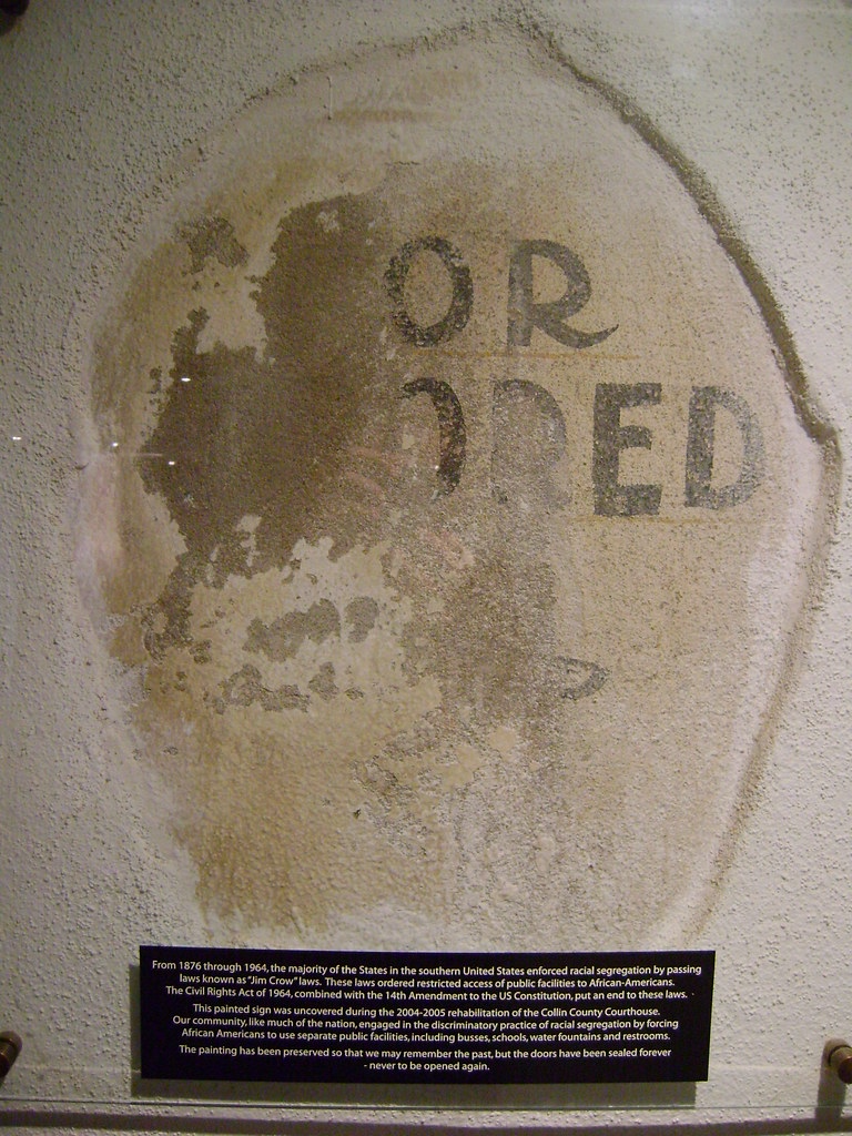 Museum exhibit of a bathroom sign from a courthouse in the south that says, "For colored."