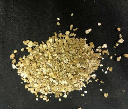 A small mound of brown vermiculite grains