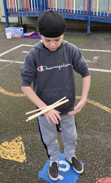 child balancing 4 sticks