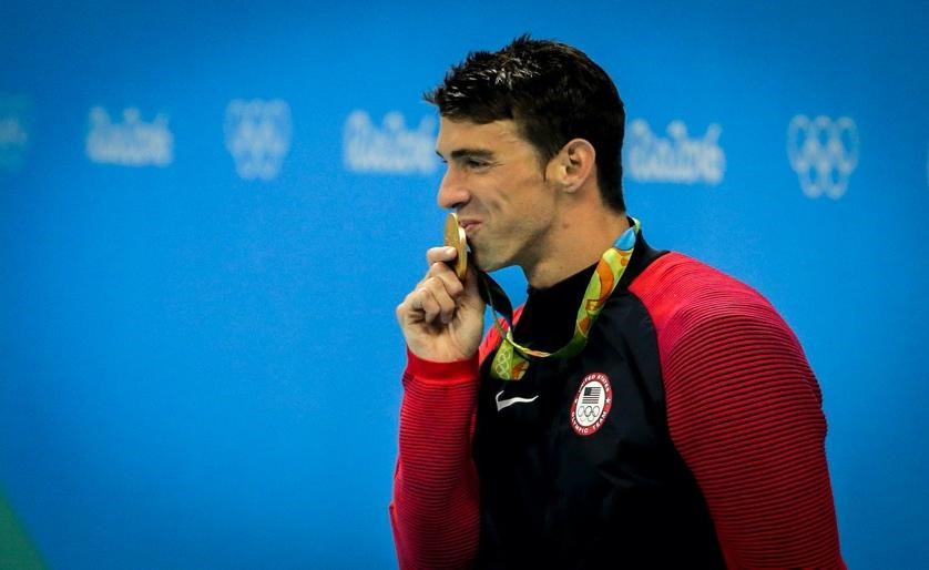 Michael Phelps kissing his gold medal from the 200m Medley at the 2016 Rio Olympics (Borges, 2016)