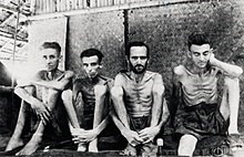 Black and white photo of 4 emaciated men 