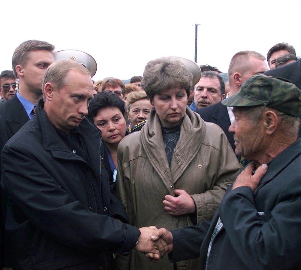photo of Putin shaking hands with a older man