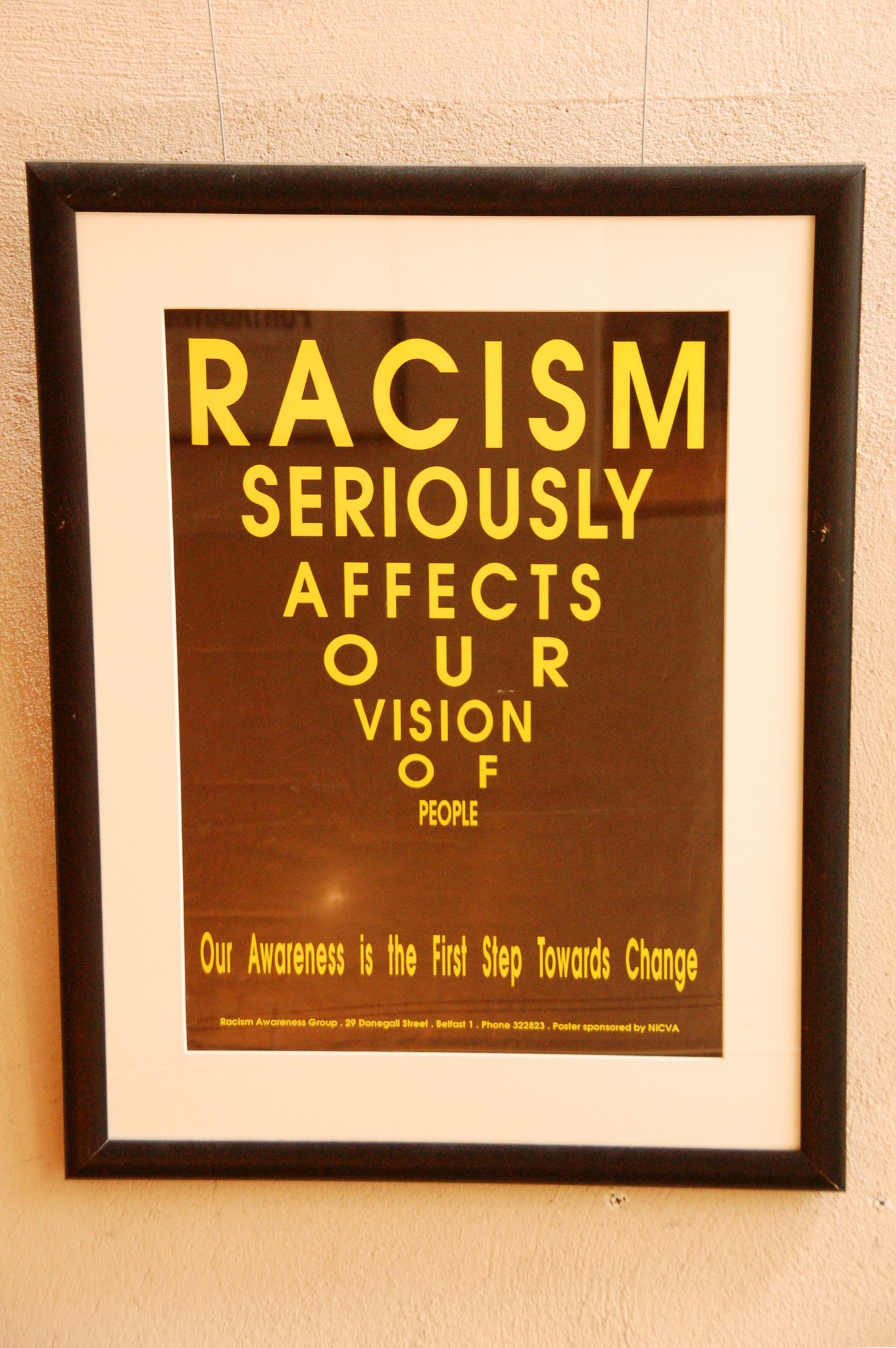 Sign says "Racism seriously affects our vision of people. Our awareness is the first step toward change."