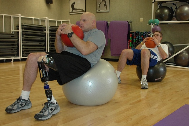 A man with a prosthetic leg works his core muscles and practices his balance.