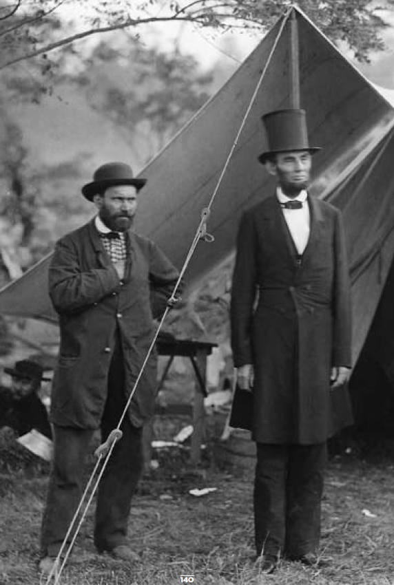 Abraham Lincoln stands outside a tent with a man. [Public Domain]